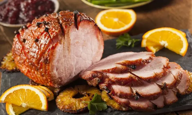 Pieczona szynka z pomarańczą i ananasem, idealna do świątecznego stołu. Marynata do szynki nadała jej piękny kolor i aromat.
