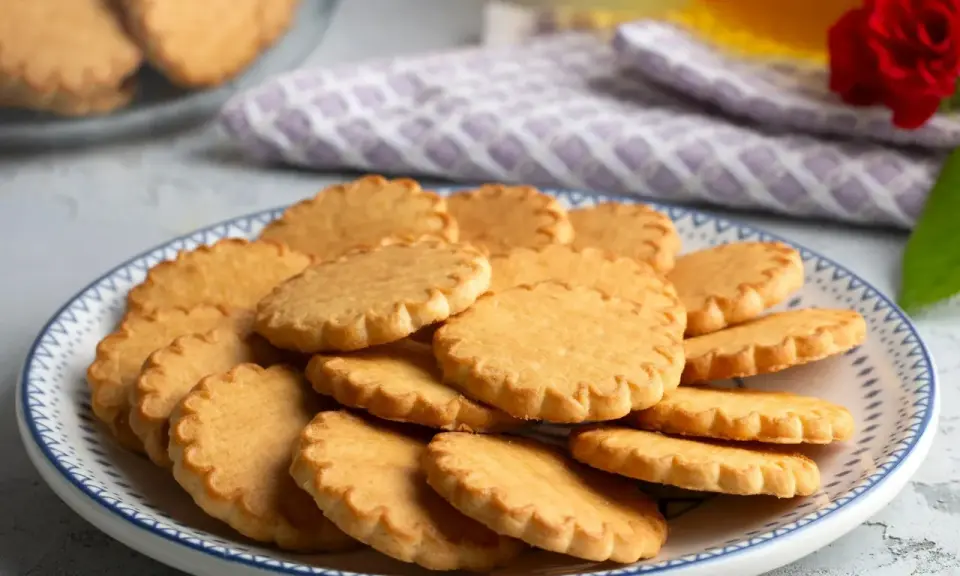 Stos ciasteczek na talerzu, idealnych do kawy. Prosty przepis na ciasteczka, który każdy może wypróbować.
