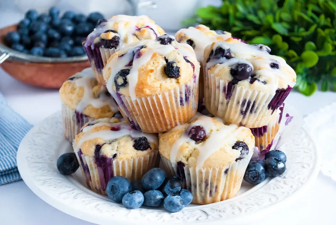 Stos pysznych muffinek z bor&oacute;wkami, polanych lukrem, ozdobionych świeżymi owocami. Idealne na deser!