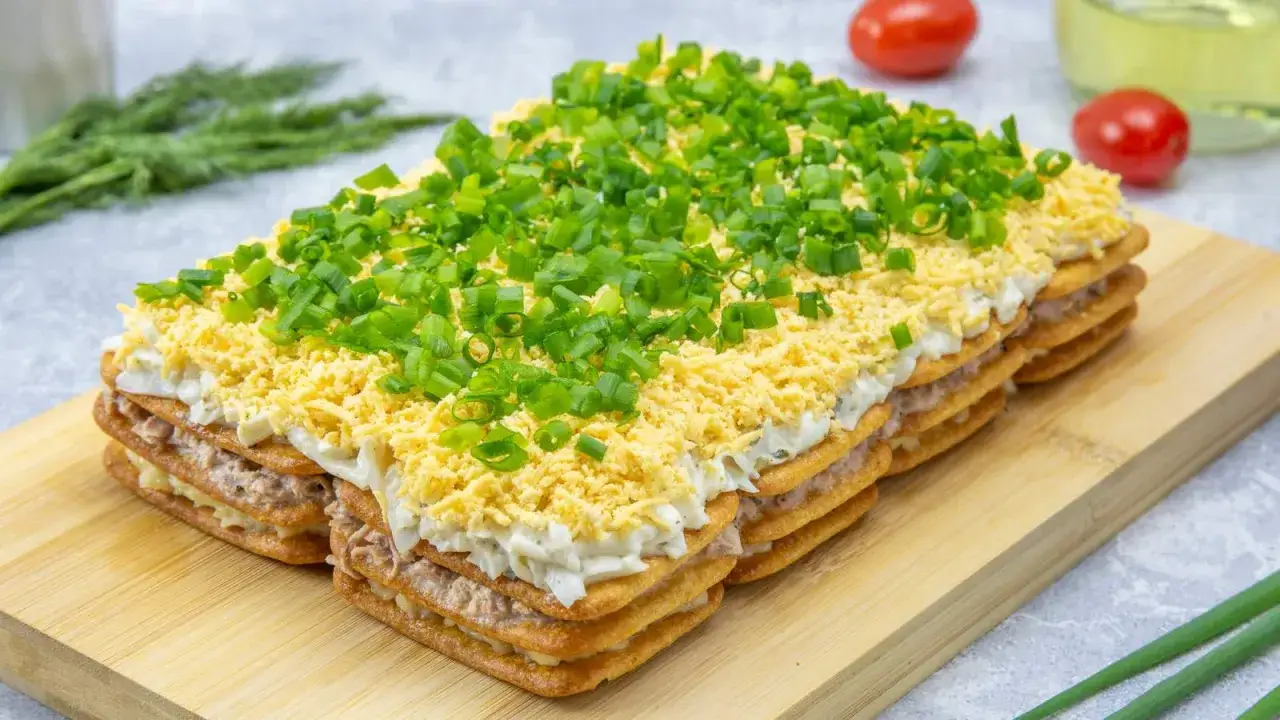 Warstwowa sałatka na imprezę z krakers&oacute;w, ryby, jajek i szczypiorku. Idealna na przyjęcie!